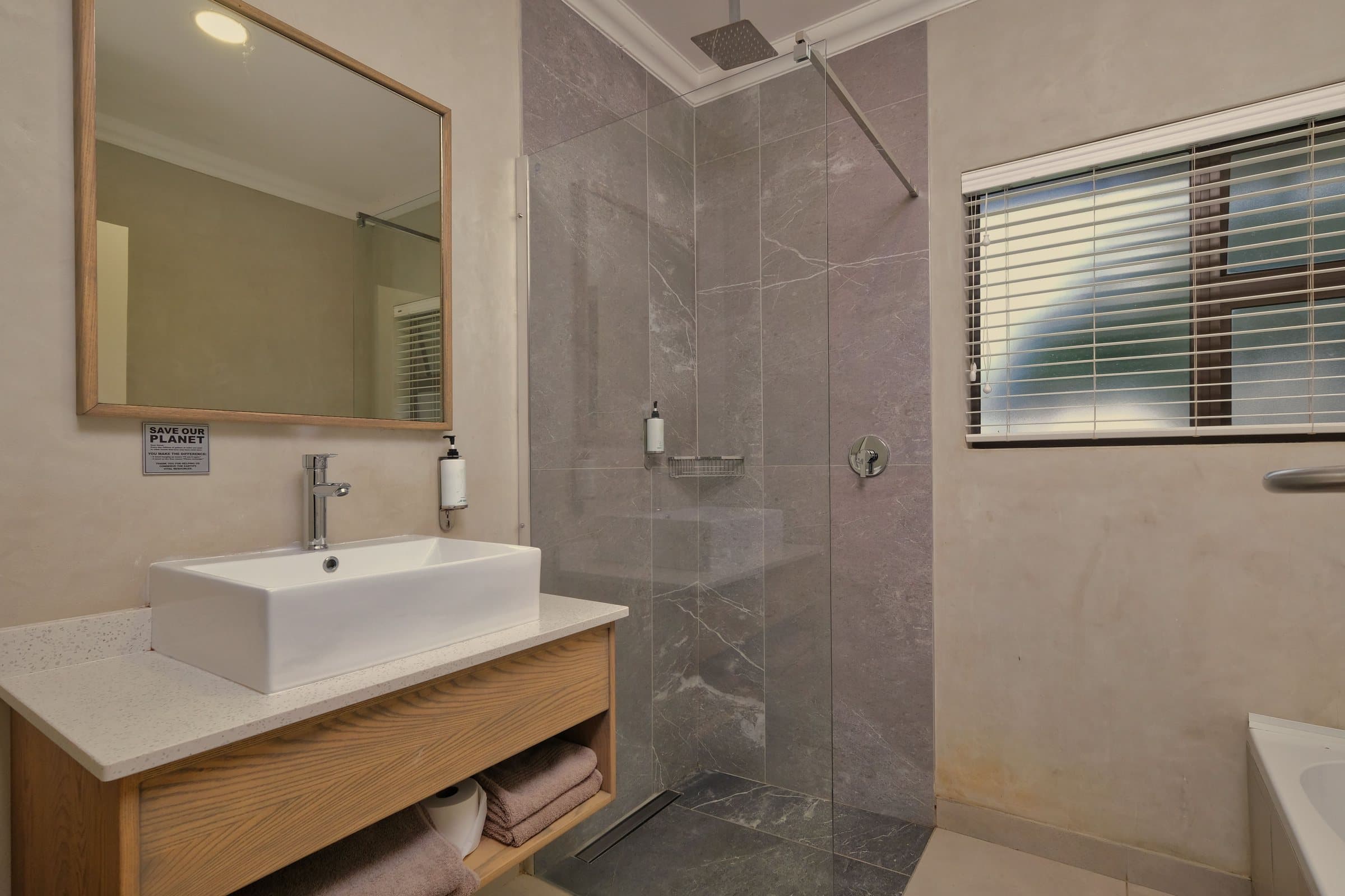 A modern bathroom with a glass walk-in shower and a wooden vanity. Illustration, not a client’s bathroom.